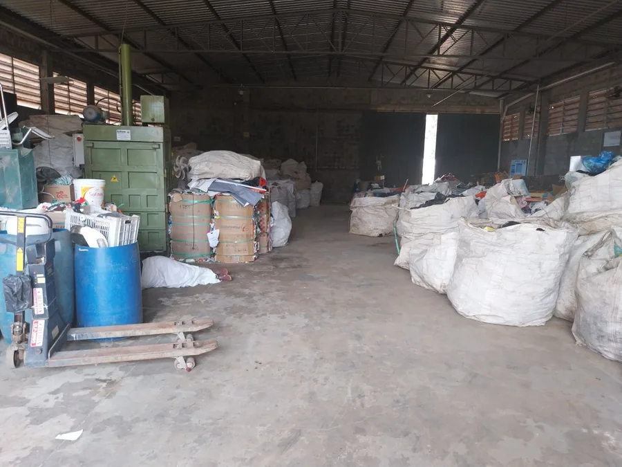 Galpão da cooperativa com prensa enfardadeira, fardos prontos e bags de material triado